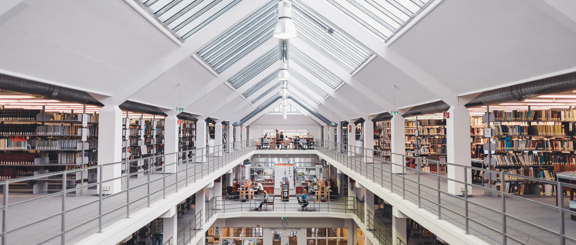 Blick in den Bibliotheksbereich A3 mit Galerien, Bücherregalen und Glasdach.
